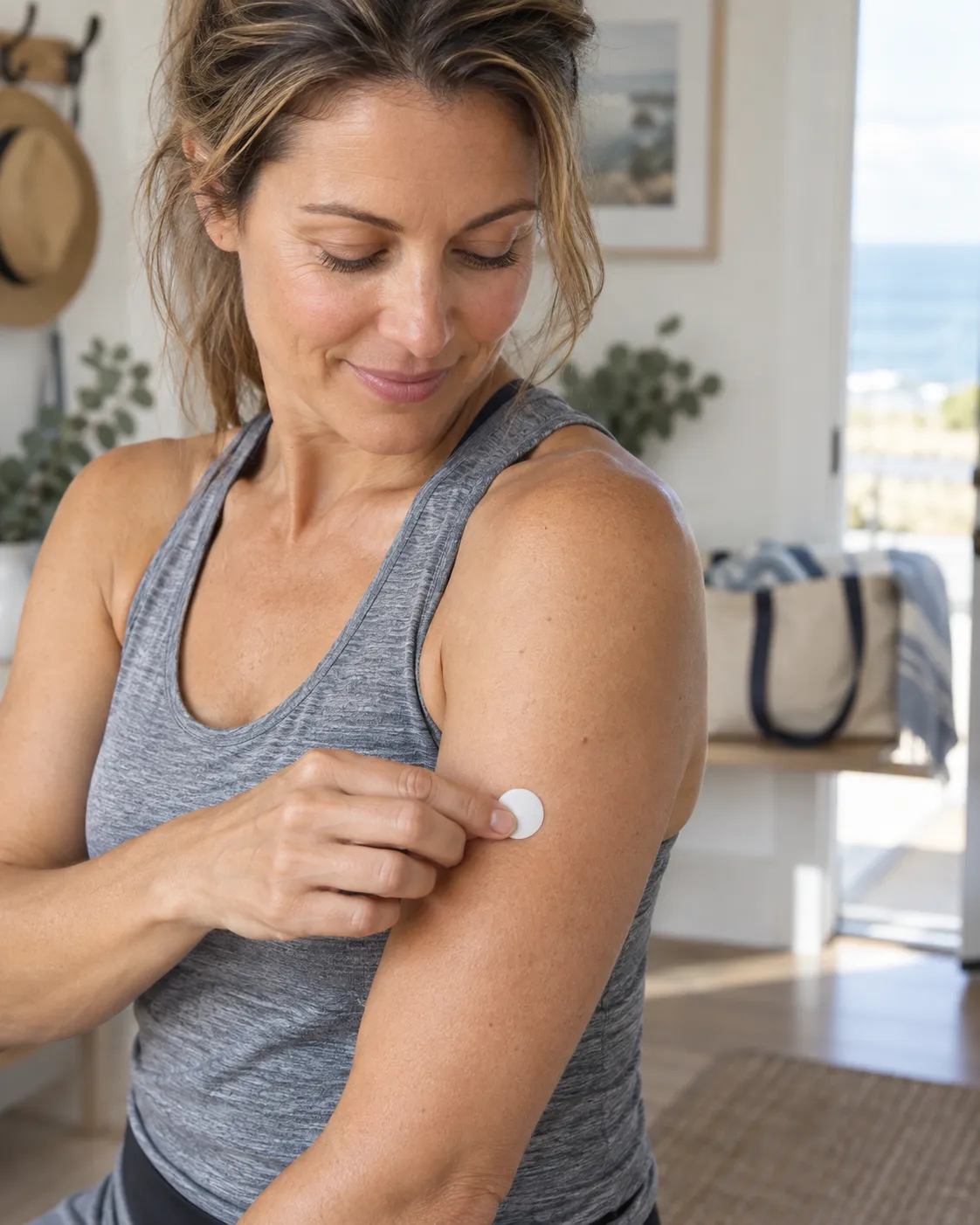Woman applying a wellness patch to her upper arm